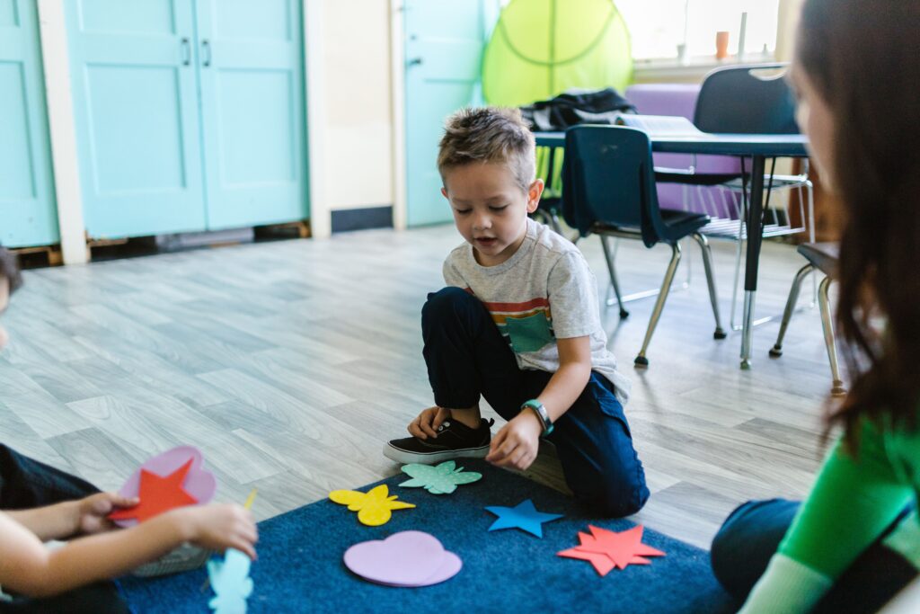 Children engage in interactive learning with colorful shapes in a kindergarten classroom.